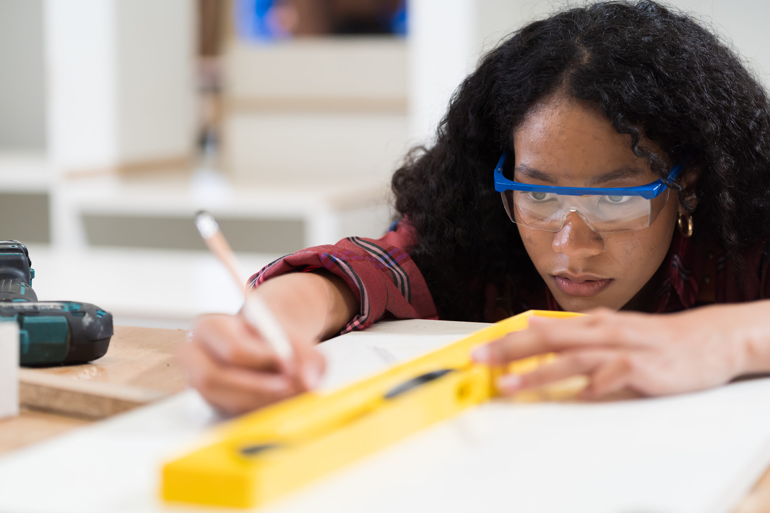 Woman Carpenter Using Precision Level Making Furniture At Wood Workshop